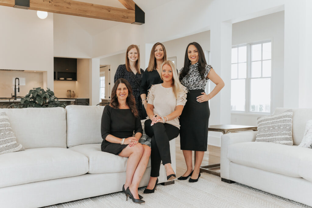 Indianapolis Realtor, the Stacy Barry Team, posing on the couch of a living room in an Indianapolis area home